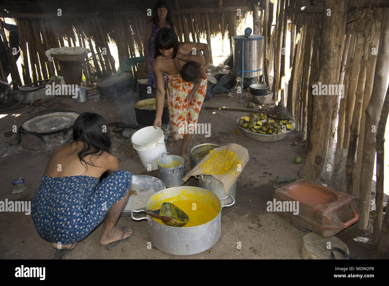 Woman village Aiha Kalapalo preparing the porridge Pequi which will be served in the men`s house Stock Photo
